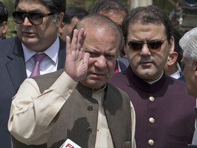 In this Thursday, June 15, 2017, photo, Pakistani Prime Minister Nawaz Sharif waves with his son Hussain Nawaz, right, outside the premises of the Joint Investigation Team, in Islamabad, Pakistan. Pakistan's Supreme Court in a unanimous decision has asked the country's anti-corruption body to file corruption charges against Prime Minister Nawaz Sharif, his two sons and daughter for concealing their assets. (AP Photo/B.K. Bangash)