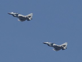 In this Sept. 3, 2015, file photo, two Chinese J-10 fighter jets fly in formation during a parade commemorating the 70th anniversary of Japan's surrender during World War II in Beijing. China on Tuesday, July 25, 2017, denied that two of its J-10 fighter jet pilots operated dangerously during an encounter with a U.S. surveillance plane in international airspace in which the American pilot took evasive action to avoid a possible collision. (AP Photo/Mark Schiefelbein, File)