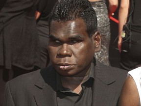 FILE - In this Nov. 27, 2011, file photo, aboriginal singer Geoffrey Gurrumul Yunupingu, left, arrives for the Australian Record Industry Association awards in Sydney, Australia. Yunupingu, renowned for singing in his native Yolngu language with a heart-rending voice and a unique guitar-playing style has died, his recording label said Wednesday, July 26, 2017. He was 46. (AP Photo/Rob Griffith, File)