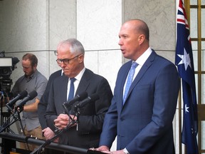 In this Tuesday, July 18, 2017, photo, Australian Prime Minister Malcolm Turnbull, center left, and Immigration and Border Protection Minister Peter Dutton, right, address the media at Parliament House in Canberra, Australia. Dutton on Friday, July 21, 2017, said Australia is disappointed that hundreds of its rejected refugees will not begin resettling in the United States this month under a deal that predates President Donald Trump's administration. (AP Photo Rod McGuirk)