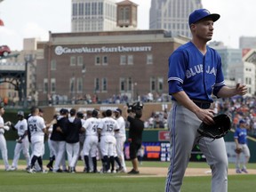 Toronto Blue Jays relief pitcher Lucas Harrell, foreground, walks off the field as the Detroit Tigers celebrate their win in the 11th inning on July 16.