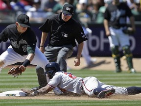 Atlanta Braves' Danny Santana, right, slides into steal third base ahead of the tag by Oakland Athletics' Ryon Healy in the seventh inning of a baseball game Saturday, July 1, 2017, in Oakland, Calif. (AP Photo/Ben Margot)