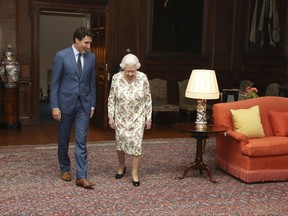 Queen Elizabeth II walks with Prime Minister Justin Trudeau during an audience at the Palace of Holyroodhouse in Edinburgh, Scotland, Wednesday July 5, 2017.