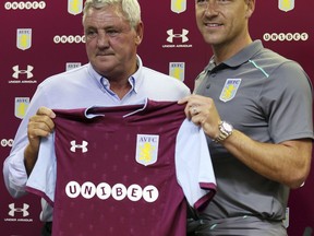New Aston Villa signing John Terry, right, with manger Steve Bruce during the media conference at Villa Park, Birmingham, England, Monday July 3, 2017.  Former England and Chelsea captain John Terry has signed a one-year deal with second-division Aston Villa, saying he is "delighted" and is looking to "help the squad achieve something special this season."(Aaron Chown/PA via AP)