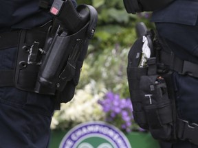 Armed police officers patrol the grounds on the opening day at the Wimbledon Tennis Championships in London Monday, July 3, 2017. (AP Photo/Tim Ireland)