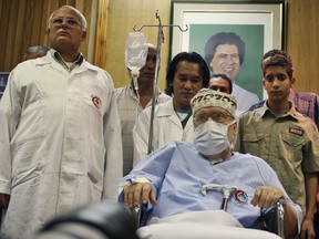 In this 2009 file photo Libyan Abdelbaset al-Megrahi, is seen below a portrait of Libyan Leader Moammar Gadhafi, at Tripoli Medical Center in Tripoli, Libya.  Relatives of Abdelbaset al-Megrahi say he was wrongly convicted of the airliner bombing, which killed 270 people.