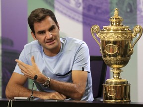 Switzerland's Roger Federer speaks next to the Men's Single's tennis trophy he won on Sunday during a photo call at The All England Lawn Tennis and Croquet Club, Wimbledon, England, Monday July 17, 2017.