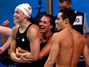 Penny Oleksiak, Kylie Masse and Richard Funk react to Yuri Kisil's freestyle swim in the mixed 4x100m medley relay final at the World Aquatics Championships in Budapest on July 26, 2017.