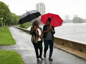 Justine Nkurunziza, left, and Tabitha Mukamusoni, asylum seekers from Burundi, walk along the Rideau River in Ottawa. Canada is the final stop in many refugees’ desperate journey to escape the summary executions, assassinations and torture racking Burundi.