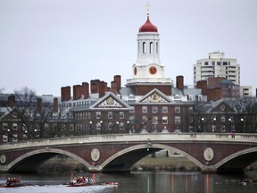 In this March 7, 2017 file photo, rowers paddle along the Charles River past the Harvard College campus in Cambridge, Mass.