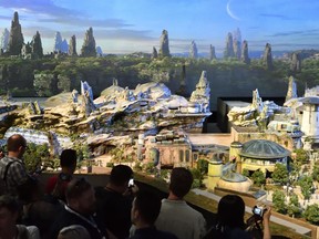 Members of the media get their first look at a 50-foot, detailed model of "Star Wars" land during a media preview for Disney's D23 Expo in Anaheim, Calf., on Thursday, July 13, 2017. (Jeff Gritchen/The Orange County Register via AP)