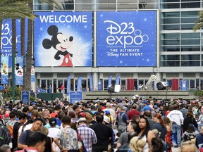 A crowd of people wait to enter the D23 Expo as crews do interviews outside the Anaheim Convention Center in Anaheim, Calif., on Friday, July 14, 2017. (Jeff Gritchen/The Orange County Register via AP)