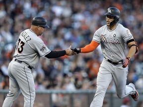 Miami Marlins' Giancarlo Stanton, right, is congratulated by third base coach Fredi Gonzalez after hitting a two-run home run off San Francisco Giants' Matt Moore during the first inning of a baseball game Friday, July 7, 2017, in San Francisco. (AP Photo/Ben Margot)