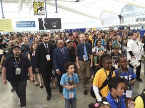 Andrew Aydin, from center left, Rep. John Lewis, D-Ga., Nate Powell and fans participate in a demonstration following a panel for "MARCH" on day three of Comic-Con International on Saturday, July 22, 2017, in San Diego. (Photo by Al Powers/Invision/AP)