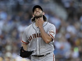 San Francisco Giants starting pitcher Madison Bumgarner touches his beard as he walks back to the mound while working against the San Diego Padres during the third inning of a baseball game Saturday, July 15, 2017, in San Diego. (AP Photo/Gregory Bull)