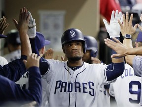 San Diego Padres' Allen Cordoba is greeted by teammates in the dugout after hitting a two-run home run during the second inning of the team's baseball game against the New York Mets on Tuesday, July 25, 2017, in San Diego. (AP Photo/Gregory Bull)
