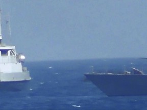 This handout image provided Tuesday, July 25, 2017, from the U.S. Navy purports to show an Iranian vessel making a close approach to a U.S. coastal patrol ship USS Thunderbolt, right. The U.S. Navy patrol boat fired warning shots near the Iranian vessel that American sailors said came dangerously close to them during a tense encounter in the Persian Gulf. Iran's Revolutionary Guard later blamed the American ship for provoking the situation. (U.S. Navy via AP)
