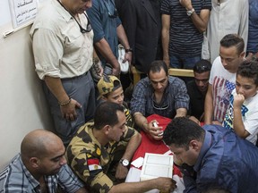 Men and boys pray over the coffin of a soldier, who was killed a day earlier in the restive Sinai Peninsula, during a funeral ceremony in the 10th of Ramadan city, about 60 kms north of Cairo, on Saturday, July 8, 2017.  The Islamic State group claimed responsibility for attacking a remote Egyptian army outpost in the Sinai Peninsula with a suicide car bomb and heavy machine gun fire. The assault killed at least 23 soldiers in the deadliest attack in the turbulent region in two years. (AP Photo/Fayed El-Geziry)