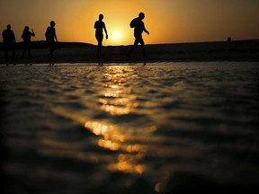 FILE - In this file picture taken Thursday, Aug. 20, 2015, tourists walk on the Giftun Island beach as the sun sets over the Red Sea in Hurghada, Egypt. Egypt's Interior Ministry said Friday, July 14, 2017 six foreign tourists, of various nationalities, were wounded when a man attacked them with a knife in the Red Sea resort of Hurghada. The ministry says the assailant was arrested immediately after the stabbings on Friday. It says the initial investigation shows the man sneaked into a hotel by swimming from a nearby beach and stabbed the tourists. (AP Photo/Hassan Ammar, File)