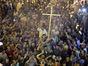 FILE - In this Friday, May 26, 2017 file photo, Coptic Christians shout slogans after the funeral service of some of the victims of a bus attack, at Abu Garnous Cathedral in Minya, Egypt. Egyptian churches are suspending pilgrimages, holidays and conferences for the remainder of July and August 2017 after authorities warned about possible attacks by Islamic militants.  ﻿(AP Photo/Amr Nabil, File)