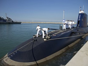 FILE - In this Jan. 12, 2016 file photo, Israeli sailors stand on a German-built  "Rahav" submarine on its arrival in to the military port in Haifa, Israel. An Israeli spokesman said Wednesday, July 12, 2017, that David Shimron, a close confidante, personal attorney and cousin of Prime Minister Benjamin Netanyahu, was questioned by police over his involvement in the purchase of German submarines following revelations that he represented the German firm involved in the $1.5 billion deal, raising the prospect of a conflict of interests. (AP Photo/Ariel Schalit, File)