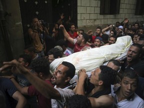 People carry the body of Sayed Tafshan, who died during clashes between security forces and residents of al-Waraq island, on the southern fringes of Cairo, Egypt, Sunday, July 16, 2017. Egypt's Health Ministry said one person was killed and 19 injured in clashes after police attempted to remove illegal buildings on state land on the island. Egypt's Interior Ministry said 31 policemen were injured. (AP Photo/Mostafa Darwish)