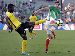 Jamaica's Kemar Lawrence, left, and Mexico's Jesus Duenas battle for the ball during the first half of a CONCACAF Gold Cup semifinal soccer match in Pasadena, Calif., Sunday, July 23, 2017. (AP Photo/Jae Hong)