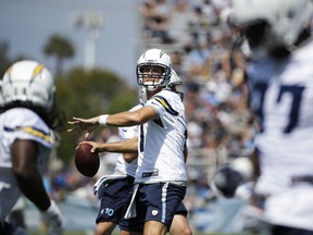 Los Angeles Chargers quarterback Philip Rivers, center, looks to throw a pass at an NFL football training camp Sunday, July 30, 2017, in Costa Mesa, Calif. (AP Photo/Jae C. Hong)