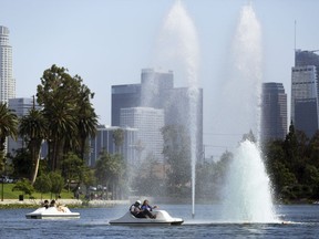 People in pedal-powered boats take advantage of a breeze creating cooling spray from fountains in Echo Park Lake near downtown Los Angeles, Thursday, July 6, 2017. A heat wave blanketing the U.S. Southwest has toppled temperature records, raised wildfire danger and sent residents to pools, beaches and even fountains for cool relief. Officials warned people to avoid strenuous activity during the day on Friday, when the worst heat was expected across Southern California. (AP Photo/Reed Saxon)