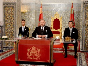 In this photo provided by the Moroccan Royal Palace, King Mohammed VI, foreground, is flanked by his brother Prince Moulay Rachid, right, and Crown Prince Moulay Hassan, during a speech to the nation on the occasion of the 18th anniversary of ascending to the throne, at the royal palace in Tetouan, northern Morocco, on Saturday July 29, 2017. (Moroccan Royal Palace via AP)