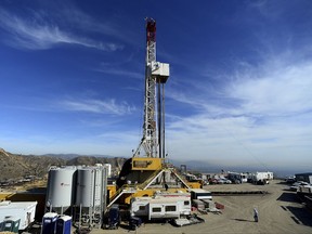 FILE - In this Dec. 9, 2015, file pool photo, crews work on a relief well at the Aliso Canyon facility above the Porter Ranch area of Los Angeles. Two state agencies said Wednesday, July 19, 2017, that the Southern California Gas Co., can resume storing natural gas at the Aliso Canyon facility, which stopped operations in the wake of an October 2015 blowout. However, storage will be restricted to about 28 percent of the field's capacity. (Dean Musgrove /Los Angeles Daily News via AP, Pool)