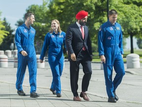 Canada's newest astronauts Jennifer Sidey and Joshua Kutryk, back, arrive at the Canadian Space Agency with Navdeep Bains, Minister of Innovation, Science and Economic Development and astronaut Jeremy Hansen, right, in Saint-Hubert, Que., Tuesday, July 4, 2017. THE CANADIAN PRESS/Graham Hughes