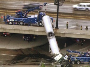 In this photo from video provided by KMOV-TV, emergency responders work to lower a tanker truck to the ground after it crashed off an Interstate 44 overpass in downtown St. Louis, Thursday, July 27, 2017. (KMOV-TV via AP)