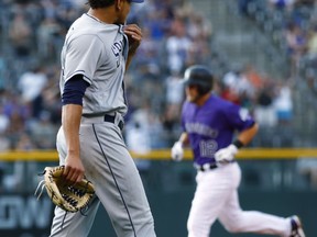 San Diego Padres starting pitcher Dinelson Lamet, front, looks back at Colorado Rockies' Mark Reynolds as he circles the bases after hitting a three-run home run off Lamet in the first inning of a baseball game Tuesday, July 18, 2017, in Denver. (AP Photo/David Zalubowski)