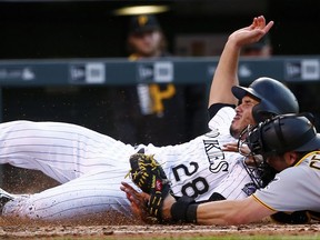 Colorado Rockies' Nolan Arenado is tagged out by Pittsburgh Pirates catcher Francisco Cervelli (29) during the fifth inning of a baseball game Saturday, July 22, 2017, in Denver. (AP Photo/Jack Dempsey)