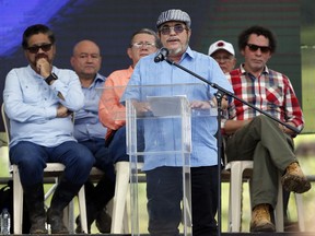 FILE - In this June, 27, 2017 file photo, Rodrigo Londono, also known as Timoleon Jimenez or Timochenko, the top commander of the Revolutionary Armed Forces of Colombia, FARC, gives his speech during an act to commemorate the completion of the disarmament process of FARC rebels, in Buenavista, Colombia. On Sunday, July 2, 2017, Timochenko was hospitalized with stroke, and remains in intensive care in Colombia. (AP Photo/Fernando Vergara, File)