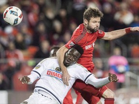 Toronto FC's Drew Moor battles for the ball with Philadelphia Union's C.J. Sapong during the first half of MLS soccer playoff action in Toronto, Wednesday October 26, 2016. THE CANADIAN PRESS/Mark Blinch