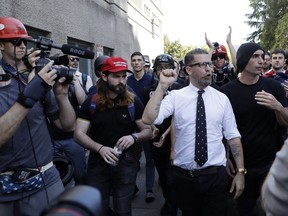 Gavin McInnes is surrounded by supporters after speaking at a rally Thursday, April 27, 2017, in Berkeley, Calif. McInnes, co-founder of Vice Media and founder of the pro-Trump "Proud Boys," spoke at a park gathering later in the day. Until earlier this week, it would have been a safe to assume few Canadians had heard of the Proud Boys. That changed on Canada Day, when five young men in matching black polo shirts disrupted an Aboriginal ceremony in Halifax. THE CANADIAN PRESS/AP-Marcio Jose Sanchez