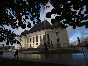 A pedestrian walks past the Supreme Court of Canada in Ottawa, Oct. 18, 2013. The Supreme Court ruled this morning the National Energy Board bungled its duty to consult indigenous communities before approving a proposed development in Nunavut.