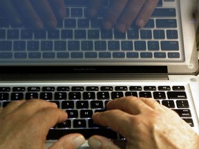 Hands type on a computer keyboard