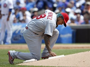 St. Louis Cardinals starting pitcher Carlos Martinez writes on the back of the mound during the first inning of a baseball game against the Chicago Cubs game Friday, July 21, 2017, in Chicago. (AP Photo/Charles Rex Arbogast)
