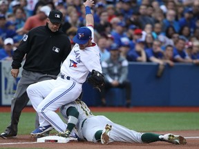 Third baseman Josh Donaldson of the Toronto Blue Jays tries to keep his balance as he tags out Oakland A's Rajai Davis on an attempted steal of third base during MLB action Monday night at Rogers Centre. The Jays snapped a three-game losing streak by virtue of a 4-2 victory.