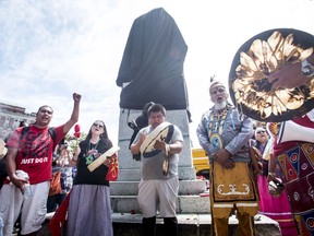 Activists protest at the base of the Edward Cornwallis statue after city staff covered it with a black sheet in Cornwallis Park in Halifax on Saturday, July 15, 2017. Protesters who pledged to remove a statue of Halifax's controversial founder Saturday say they came away victorious after the monument to Edward Cornwallis was covered in a tarp.