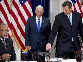 Vice President Mike Pence, center, and Kansas Secretary of State Kris Kobach, right, accompanied by Former Mayor of Cincinnati Ken Blackwell, left, take their seats for the first meeting of the Presidential Advisory Commission on Election Integrity at the Eisenhower Executive Office Building on the White House complex in Washington, Wednesday, July 19, 2017. (AP Photo/Andrew Harnik)