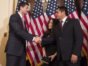 Speaker of the House Paul Ryan, R-Wis., left, shakes hands with Representative-elect Jimmy Gomez, D-Calif., right, as Mary Hodge, Gomez's wife, looks on after a ceremonial swearing-in on Capitol Hill in Washington, Tuesday, July 11, 2017. (AP Photo/Carolyn Kaster)