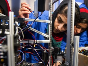 Afghanistan team member Lisa Azizi trouble shoots the teams robot entry prior to the opening ceremony for the FIRST Global Challenge 2017, in Washington, Sunday, July 16, 2017. They will be competing against entrants from more than 150 countries in the FIRST Global Challenge. It's the first annual robotics competition designed to encourage youths to pursue careers in math and science. (AP Photo/Cliff Owen)