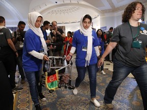 Rodaba Noori, left, and Lida Azizi, carry their teams robot to compete with the Afghanistan team in the FIRST Global Robotics Challenge, Monday, July 17, 2017, in Washington. The challenge is an international robotics event with teams from over 100 countries. (AP Photo/Jacquelyn Martin)