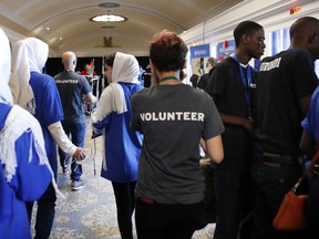 In this July 17, 2017, photo, the Afghanistan team, left, walks past two of the team members from Burundi, at right in black shirts, during the FIRST Global Robotics Challenge in Washington. Police tweeted missing person fliers Wednesday asking for help finding the teens, who had last been seen at the FIRST Global Challenge around the time of Tuesday's final matches. The missing team members include two 17-year-old girls and four males ranging in age from 16 to 18. (AP Photo/Jacquelyn Martin)