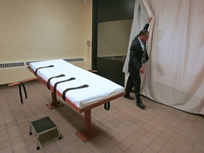 Prison official Larry Greene pulls back the curtain between the death chamber and the witness room at a state prison in Lucasville, Ohio, in a November 2005 file photo.