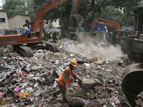 Rescuers look for survivors on the second day after a five-story building collapsed in the Ghatkopar area of Mumbai, India, Wednesday, July 26, 2017. A five-story building came crashing down Tuesday in Mumbai, India's financial and entertainment capital, killing at least 12 people and injuring 12 others, police said. Another dozen people were feared trapped under the rubble.(AP Photo/Rafiq Maqbool)